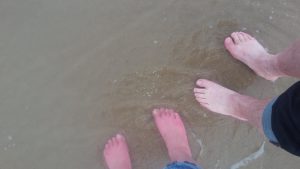 met de voeten in het water